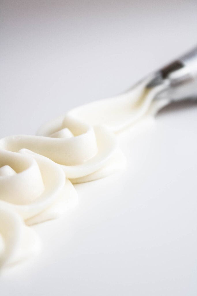 A line of cream cheese buttercream piped with a piping tip. 